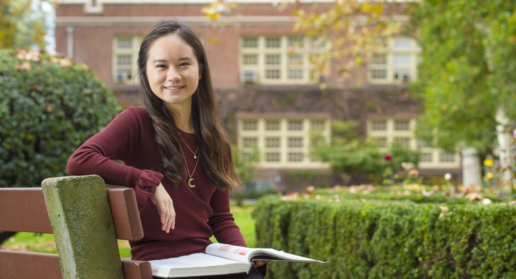 Language student sitting on campus bench
