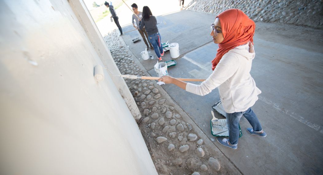 Students painting wall for service day