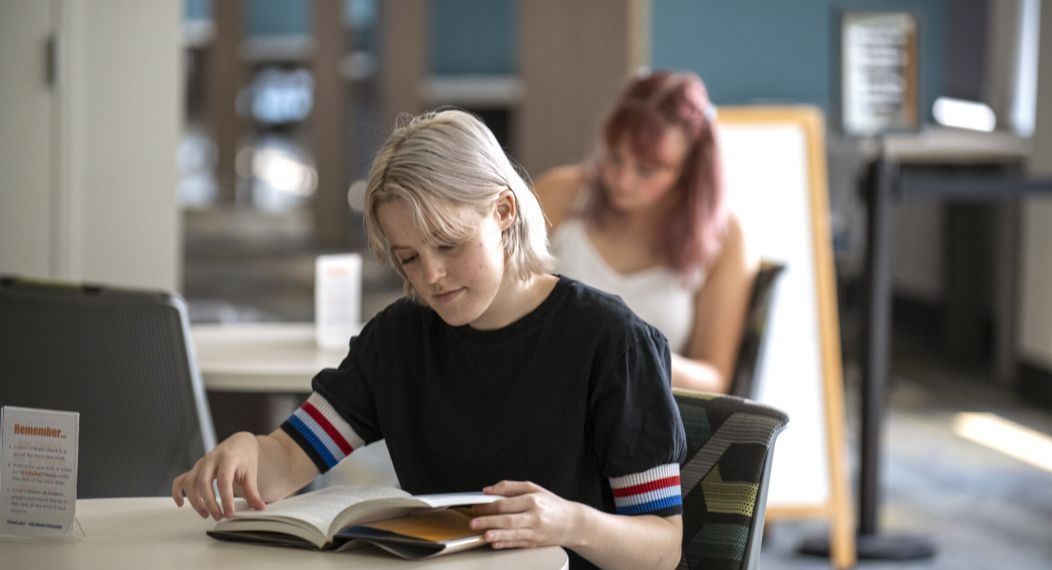 Student reading in the Academic Commons