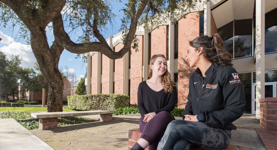 two students sit outside Wendell Phillips Center