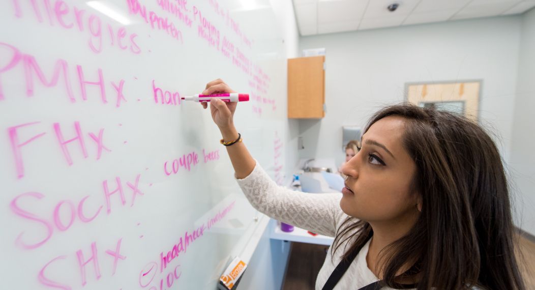 a student writes on a white board