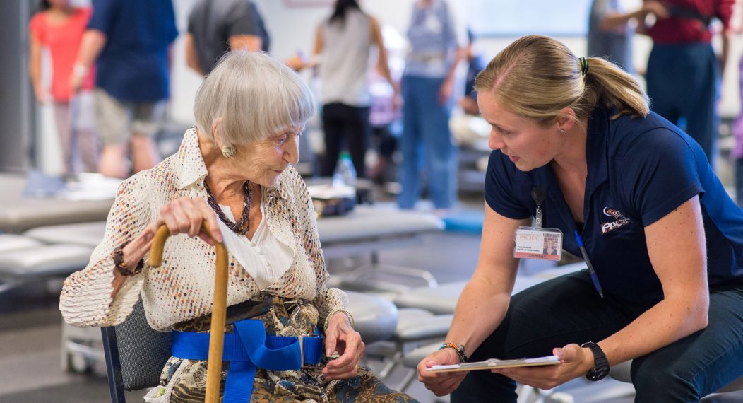 an elderly woman talks with a health sciences student