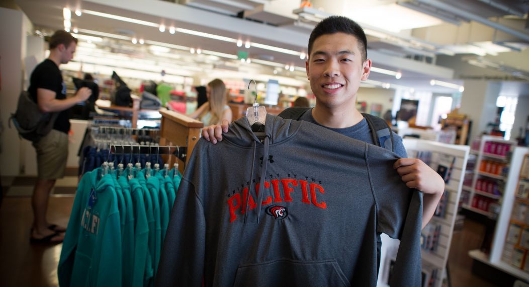 student holding up shirt in Stockton bookstore