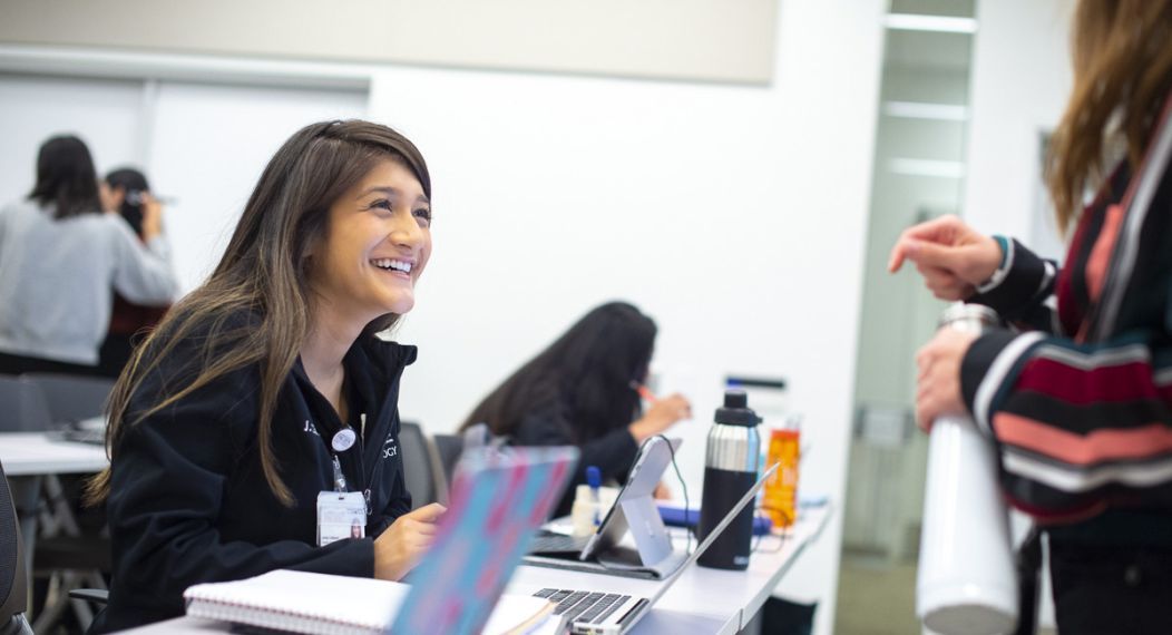 students smiling at desk