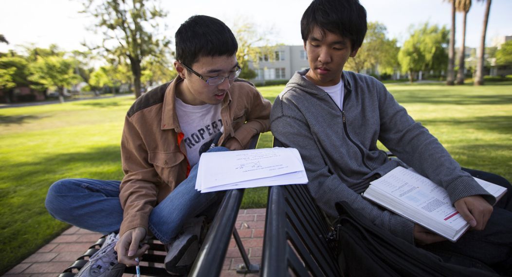 two students studying math together outside