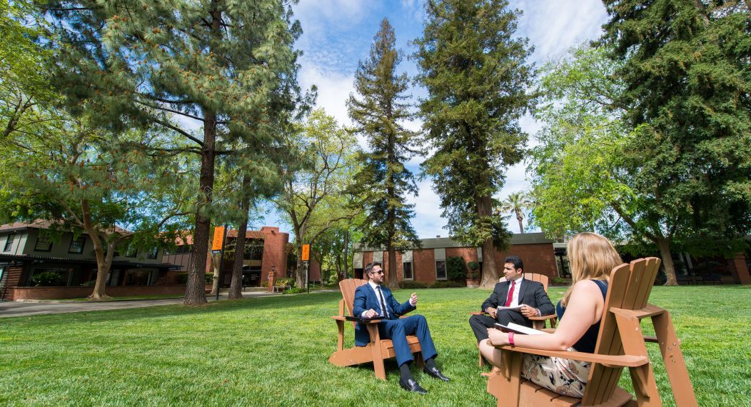 the quad with student on the Adirondack chairs
