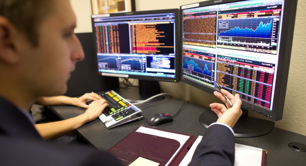 student looking at a screen analyzing stocks