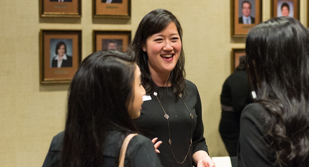 Alumni board member speaks with students at an event.