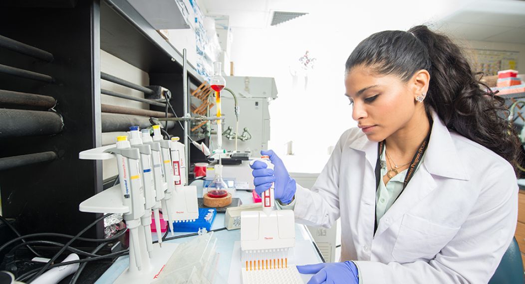 Student doing research holding a micropipette