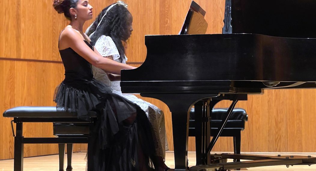 Two students playing the piano