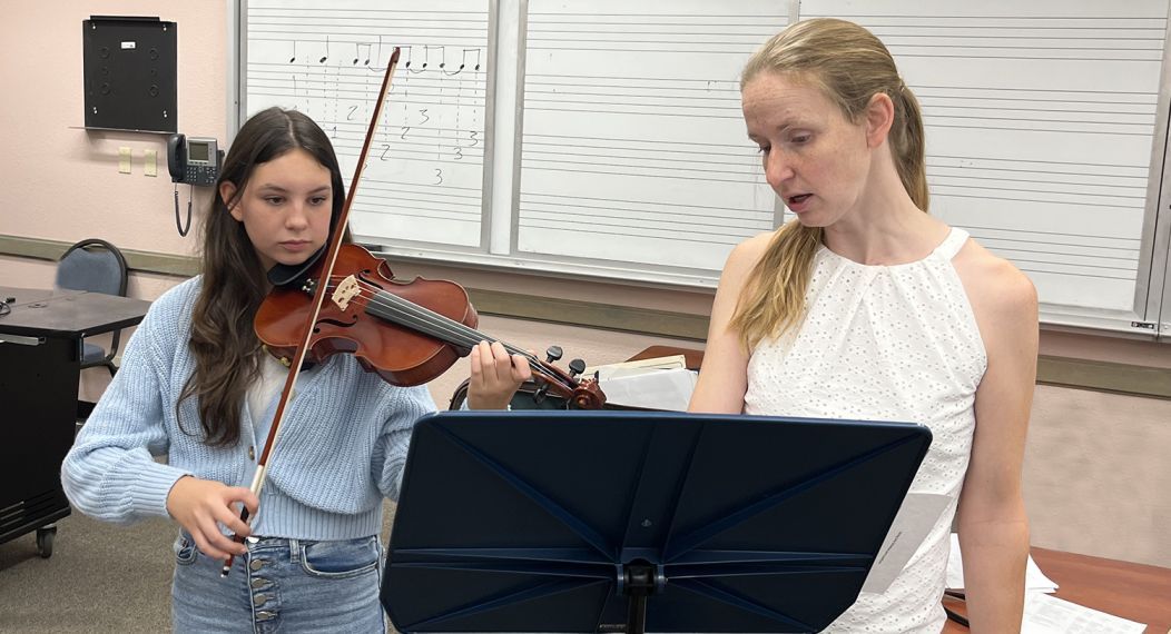 Violin professor instructing a student playing a violin