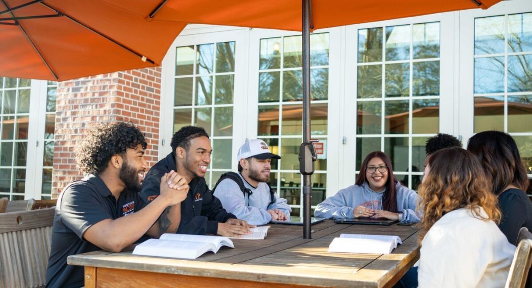 a group of CIP students sit together at an outdoor table