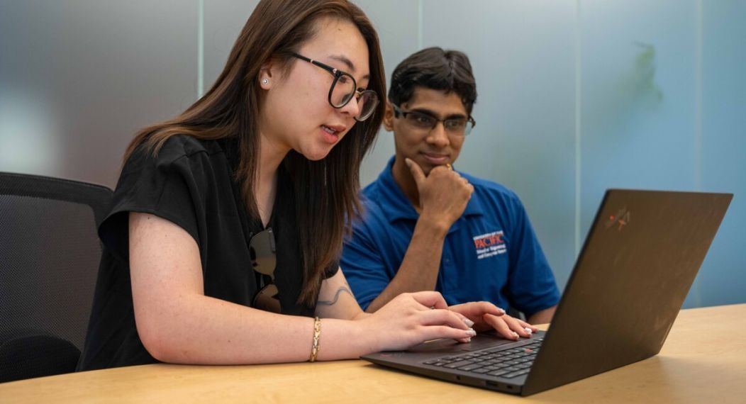 a student and a professor working together at a conference table