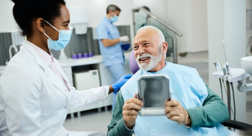 happy older man talking to dentist