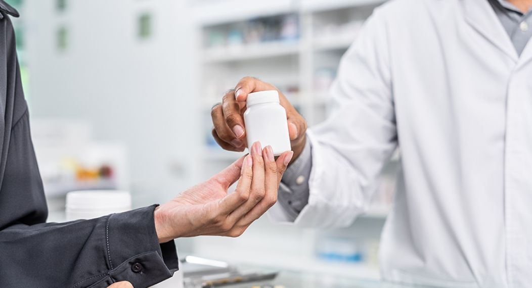 Close up shot of a patient interacting with a pharmacist at the counter