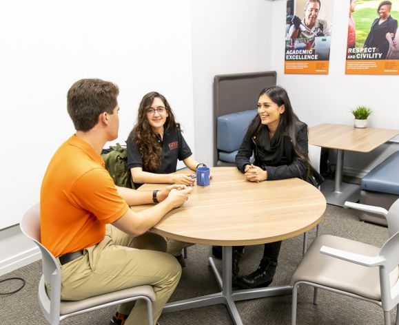 education students sitting around a table talking