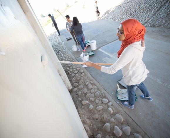 Students painting wall for service day