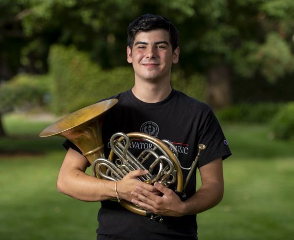 student holding French Horn