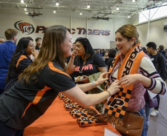 staff member giving student a Tiger scarf