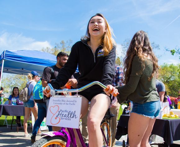 Student riding bike at health fair
