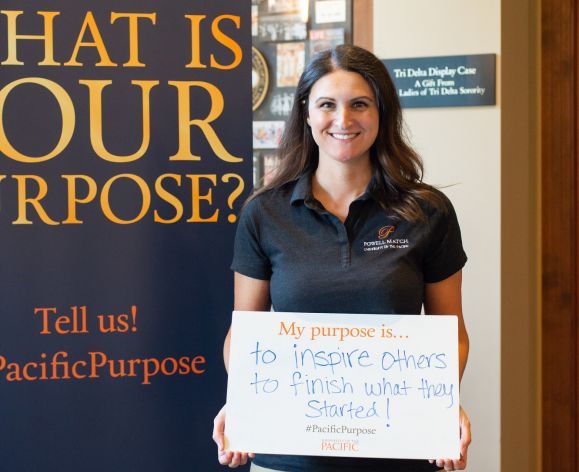 Degree completion student holding sign that says "My purpose is to inspire others to finish what they started"