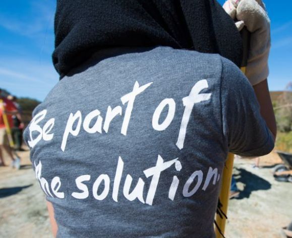 Pacific student volunteer wearing t-shirt that says, "Be part of the solution".