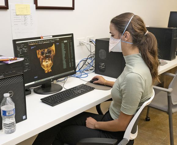 woman sitting at computer looking at orthodontics imaging