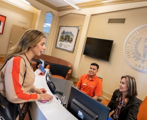 student and two staff members at one stop student center