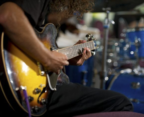 persons playing the guitar and a drum kit