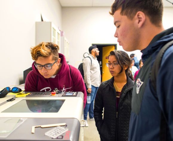 students watching their project get printed out in the TIES lab