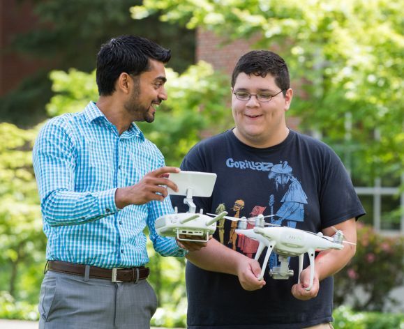 Dean Niraj Chaudhary and student working with a drone