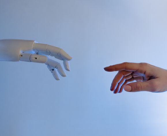 robotic hand reaching for human hand, parody of famous painting
