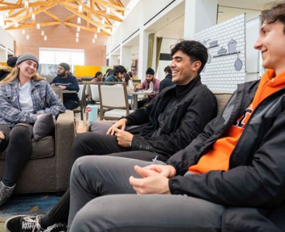 three students sit on couches in the DeRosa University Center