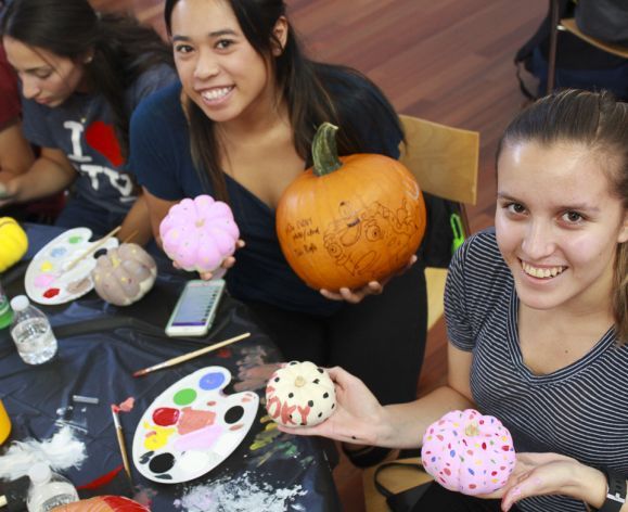 Pre-pharmacy students painting pumpkins 