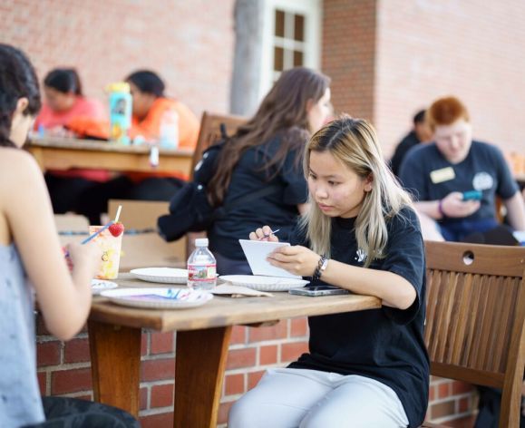 students at tables outside the duc