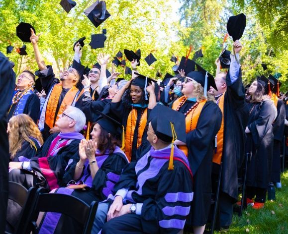 pacific graduates throwing caps in air