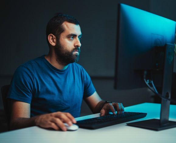 Cybersecurity student works on a computer in the lab