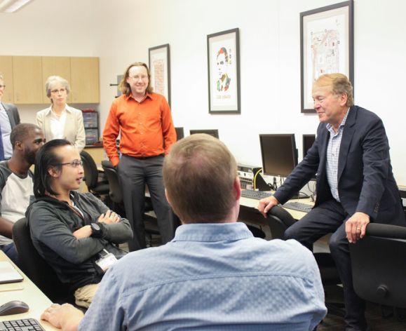 Students gather around a guest lecturer in Cybersecurity class