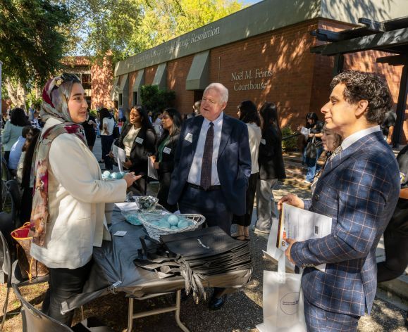 students outside talking to an employer