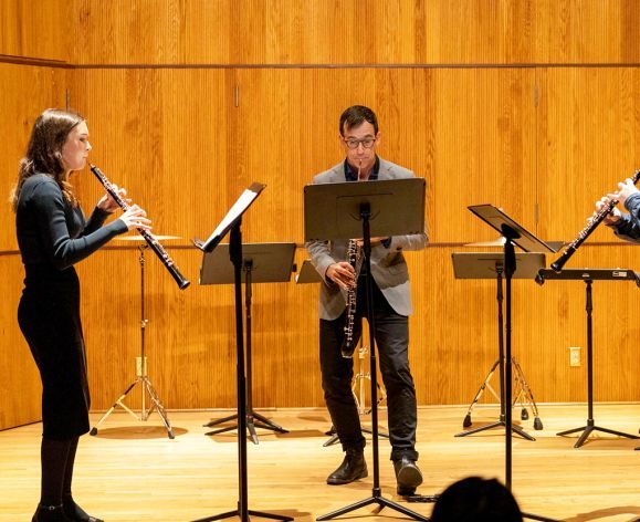 Students playing woodwind instruments in a small ensemble