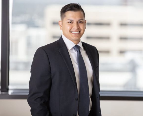Man in black suit smiles for the camera