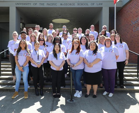 A group photo of people wearing matching purple shirts