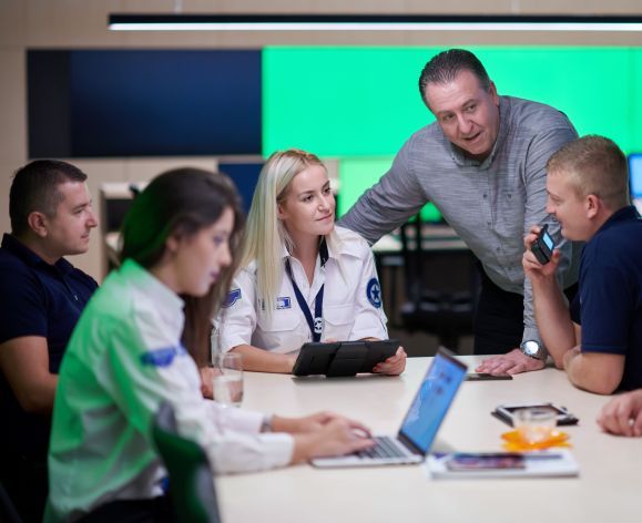 Image shows a group of people gathered around a table. 