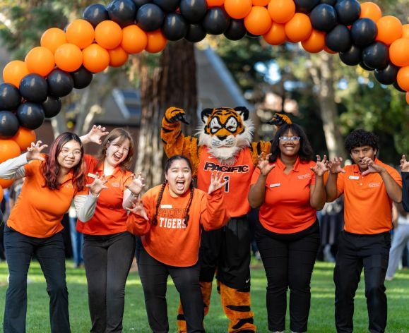 Admission ambassadors pose with the Powercat mascot under a balloon arch