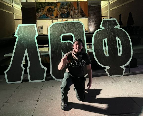 man standing in front of greek letters 
