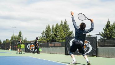 Tennis student serving