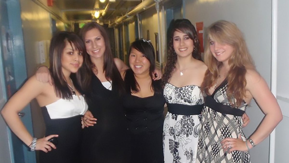 Five friends stand in a hallway in Southwest Hall. 
