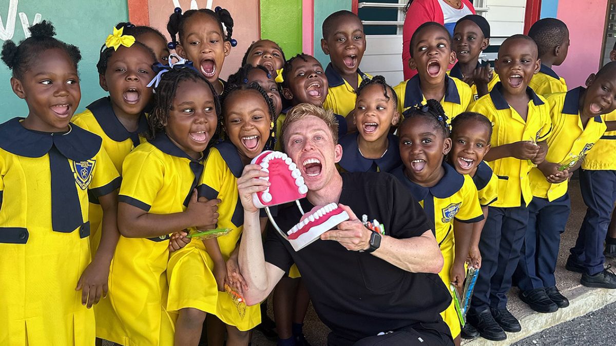group photo with kids in yellow with dental volunteer