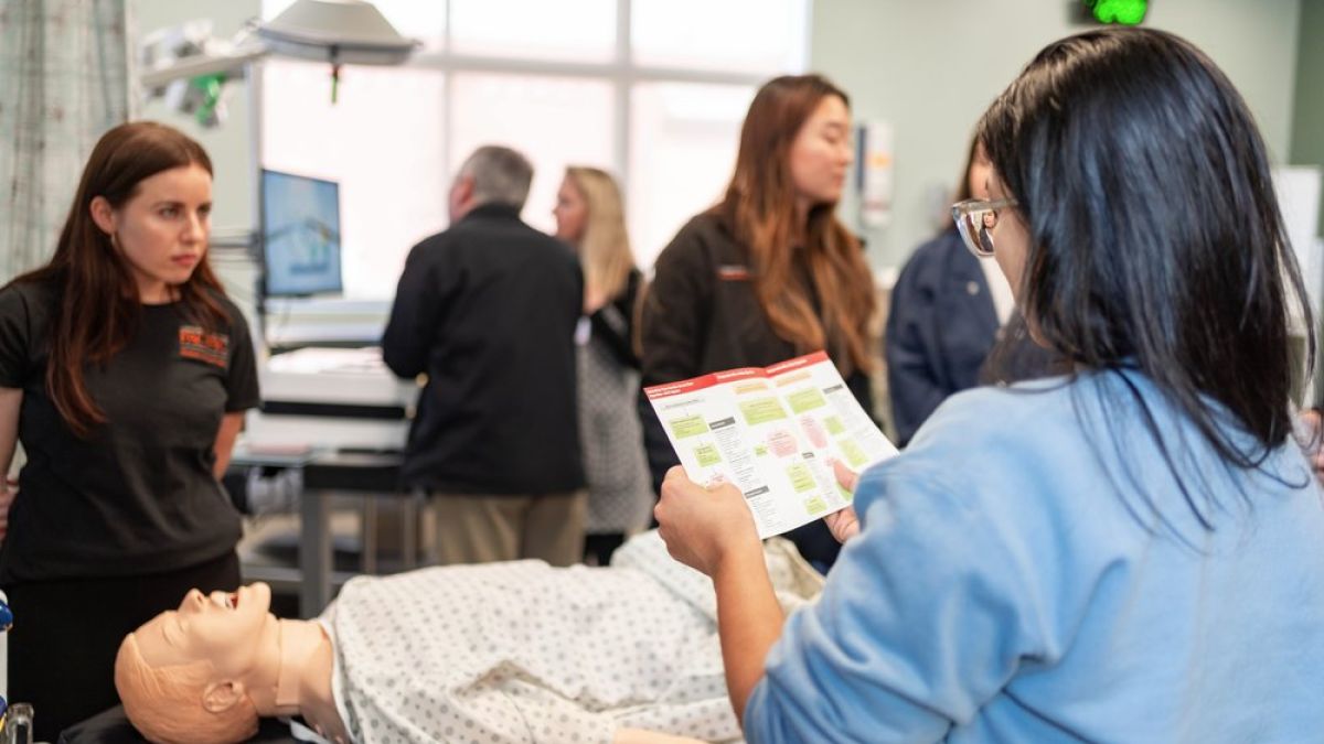 Image shows a student reviewing instructions in clinical skills lab